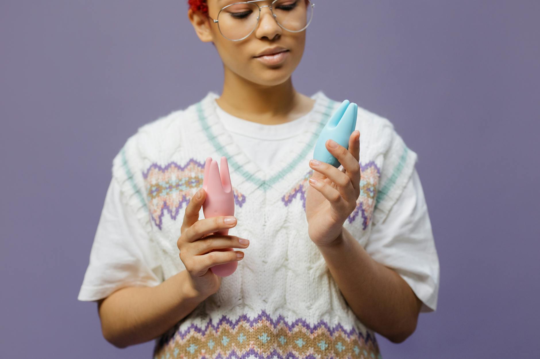 Woman holding colorful silicone vibrators, contemplating intimate choices with new partner