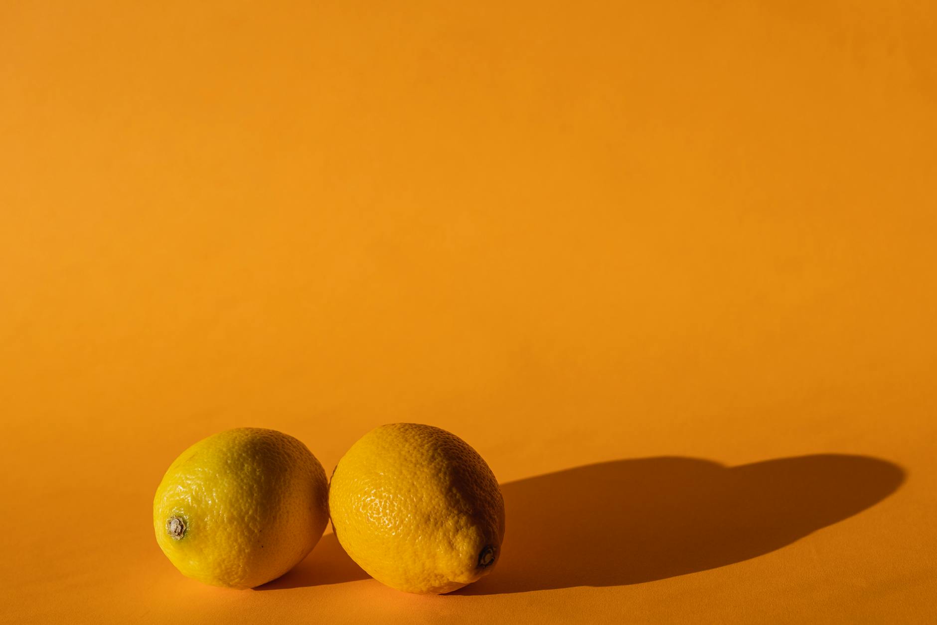 Fresh ripe lemons on a bright yellow background, symbolizing renewal and gentle reconnection