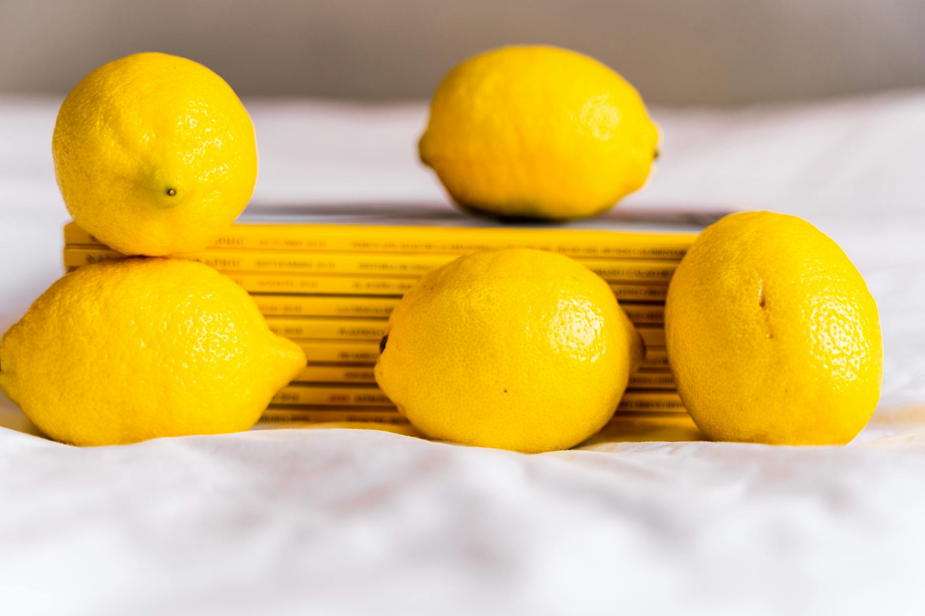 Yellow silicone vibrator surrounded by peeled fruit on a bright background, representing extended pleasure and sensuality